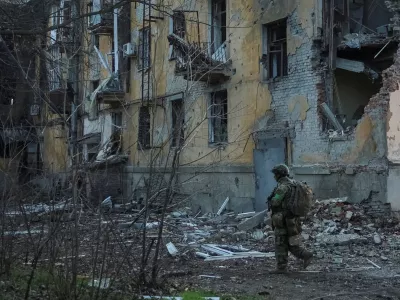 A serviceman of the 49th Separate Assault Battalion Carpathian Sich of the Armed Forces of Ukraine walks near an apartment building damaged by Russian military strike, amid Russia's attack on Ukraine, in the frontline town of Kostiantynivka in Donetsk region, Ukraine December 7, 2025. REUTERS/Anatolii Stepanov