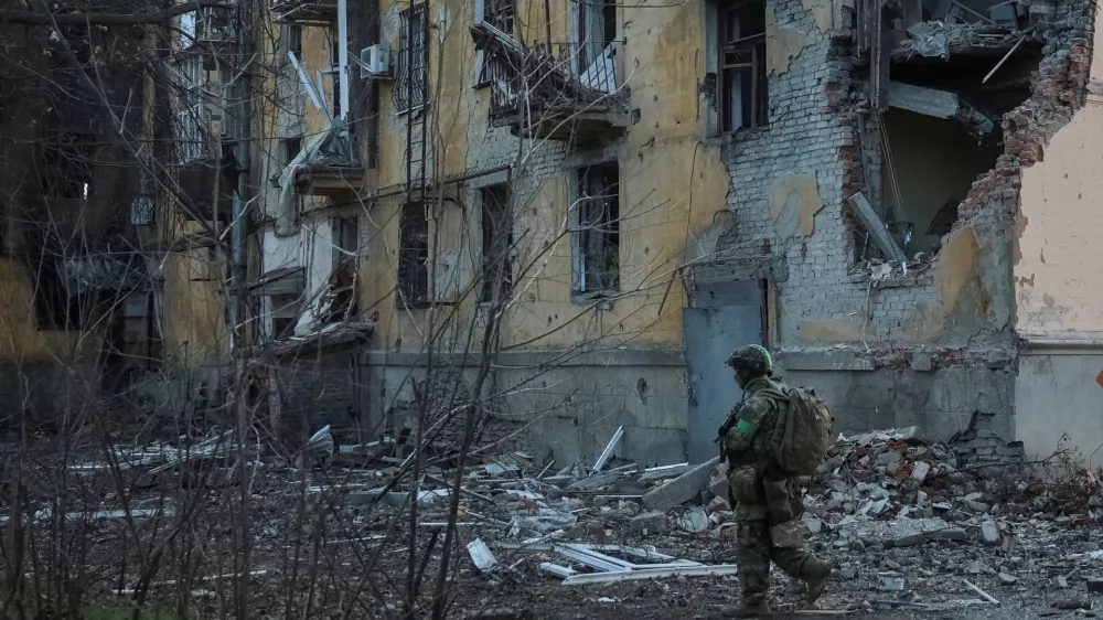 A serviceman of the 49th Separate Assault Battalion Carpathian Sich of the Armed Forces of Ukraine walks near an apartment building damaged by Russian military strike, amid Russia's attack on Ukraine, in the frontline town of Kostiantynivka in Donetsk region, Ukraine December 7, 2025. REUTERS/Anatolii Stepanov