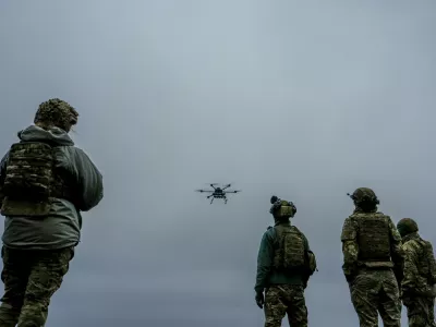 A Ukrainian drone operator from the Kraken 1654 unit, callsign Imla, left, flies a Vampire drone as other soldiers watch, during a demonstration for The Associated Press, Wednesday, Nov. 5, 2025, in Kharkiv Oblast, Ukraine. (AP Photo/Julia Demaree Nikhinson)