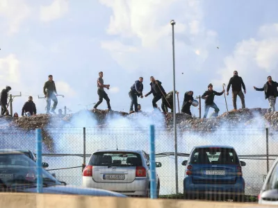 Greek farmers protesting over the delayed payment of European Union subsidies hurl stones amid tear gas at the Heraklion International Airport, in Heraklion, Crete island, Greece, December 8, 2025. REUTERS/Stefanos Rapanis   TPX IMAGES OF THE DAY