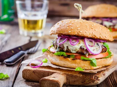 homemade burger with beef cutlet, apple, lettuce, onion and blue cheese on wooden table
