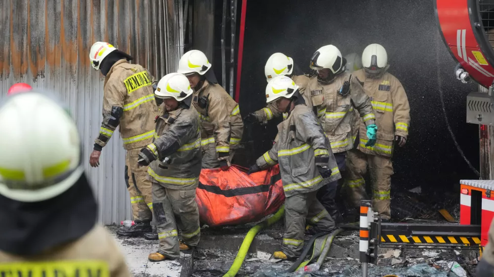 Rescuers carry out the body of a victim from the site of a fire in Jakarta, Indonesia, Tuesday, Dec. 9, 2025. (AP Photo/Dita Alangkara)