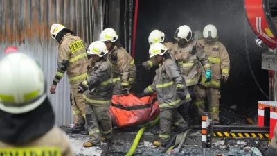 Rescuers carry out the body of a victim from the site of a fire in Jakarta, Indonesia, Tuesday, Dec. 9, 2025. (AP Photo/Dita Alangkara)