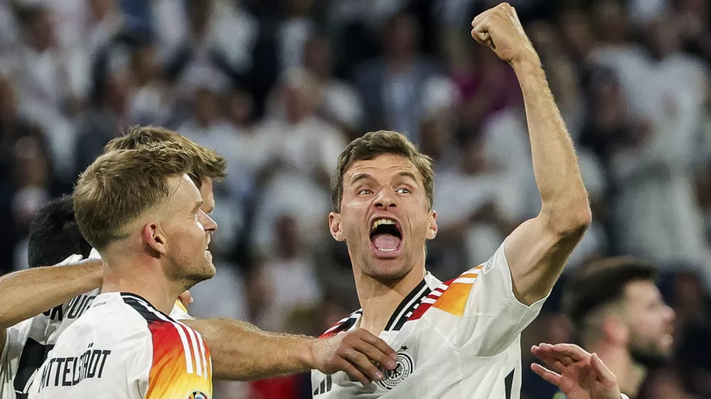 FILE - Germany's Thomas Mueller, right, celebrates during the Group A match between Germany and Scotland at the Euro 2024 soccer tournament in Munich, Germany, Friday, June 14, 2024. Germany forward Thomas M&uuml;ller has announced his retirement from international soccer after a 14-year career that included the 2014 World Cup title. (Christian Charisius/dpa via AP, File)