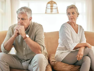 Senior couple, divorce and disagreement in conflict, fight or argument on living room sofa at home. Elderly woman and frustrated man in depression, cheating affair or toxic relationship in the house