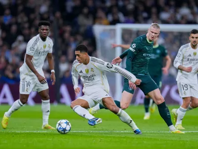 Real Madrid's Jude Bellingham, left, tussles for the ball with Manchester City's Erling Haaland during a Champions League opening phase soccer match between Real Madrid and Manchester City, in Madrid, Spain, Wednesday, Dec. 10, 2025. (AP Photo/Manu Fernandez)