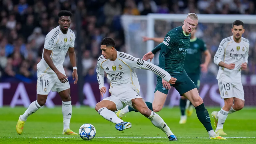 Real Madrid's Jude Bellingham, left, tussles for the ball with Manchester City's Erling Haaland during a Champions League opening phase soccer match between Real Madrid and Manchester City, in Madrid, Spain, Wednesday, Dec. 10, 2025. (AP Photo/Manu Fernandez)