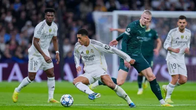 Real Madrid's Jude Bellingham, left, tussles for the ball with Manchester City's Erling Haaland during a Champions League opening phase soccer match between Real Madrid and Manchester City, in Madrid, Spain, Wednesday, Dec. 10, 2025. (AP Photo/Manu Fernandez)