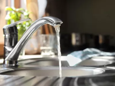 Water running from tap into kitchen sink / Foto: Liudmila Chernetska