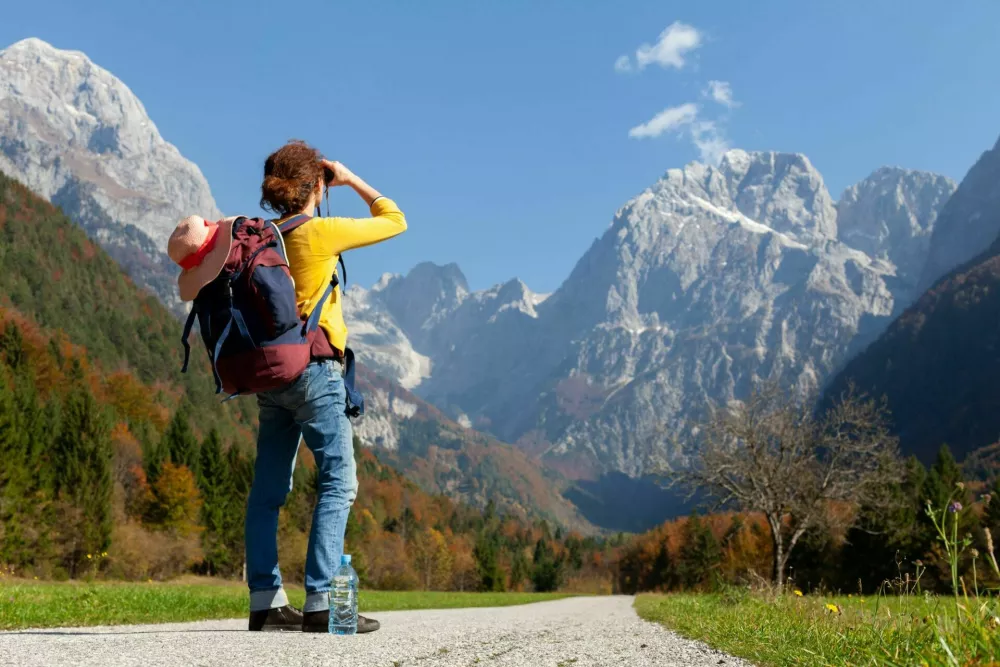 Woman Backpacker Looking Mountains Far Away on Her Road / Foto: Robert Pavsic