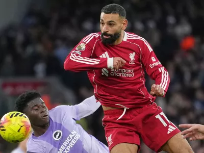 Liverpool's Mohamed Salah, right, challenges for the ball with Brighton's Carlos Baleba, left, during the English Premier League soccer match between Liverpool and Brighton and Hove Albion in Liverpool, England, Saturday, Dec. 13, 2025. (AP Photo/Jon Super) / Foto: Jon Super