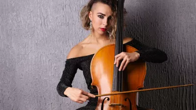 Emotional woman in an evening dress playing the cello. / Foto: Unomat