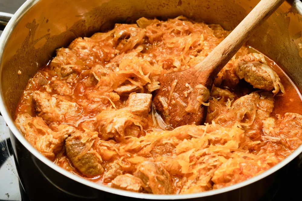Preparing hungarian szekely gulyas with pork meat, dried pepper and cabbage in cooking pot / Foto: Jan Mach