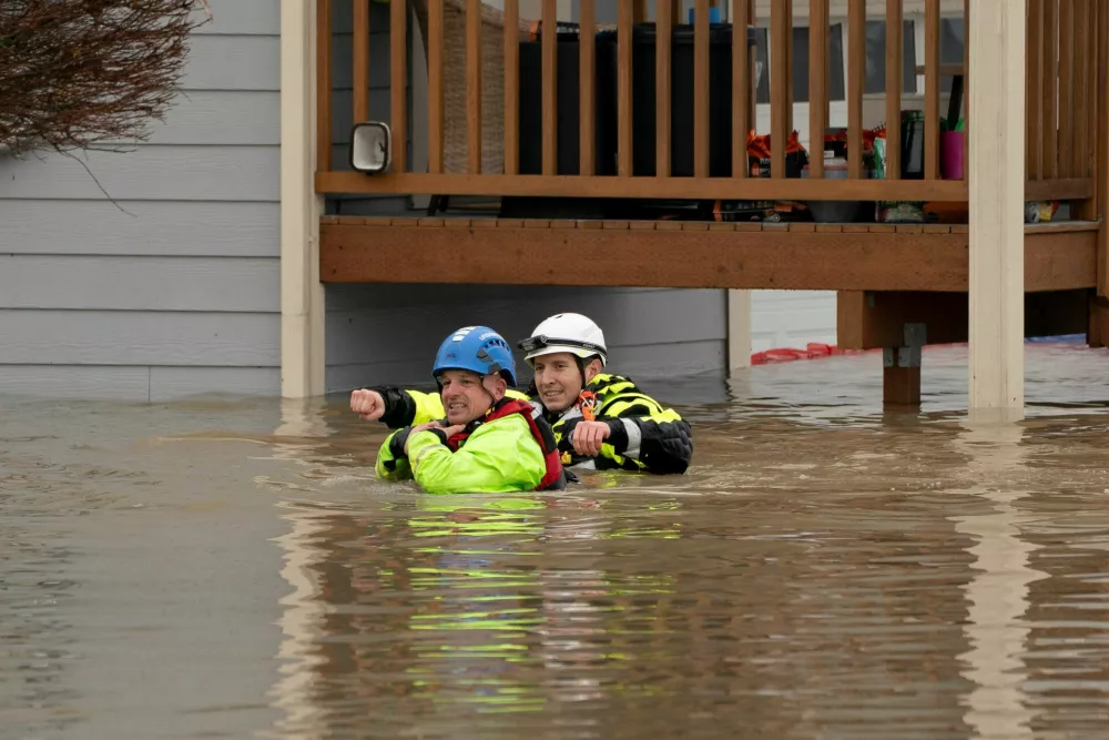 Rescue personnel prepare to evacuate residents from a home in an area flooded by the Snohomish River, as an atmospheric river brings rain and flooding to the Pacific Northwest, in Snohomish, Washington, U.S., December 11, 2025. REUTERS/David Ryder