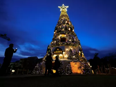 People stand near an illuminated Christmas tree during the holiday season in Batroun, northern Lebanon, December 10, 2025. REUTERS/Mohamed Azakir   TPX IMAGES OF THE DAY / Foto: Mohamed Azakir