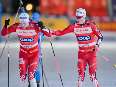 Johannes Hoesflot Klaebo of Norway, right, passes to his teammate Erik Valnes during the final of the men's Team sprint free competition at the Davos Nordic FIS Cross Country World Cup, in Davos, Switzerland, Friday, Dec. 12, 2025. (Gian Ehrenzeller/Keystone via AP)