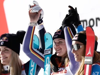 Germany's Emma Aicher, center, winner of an alpine ski, women's World Cup downhill, poses on the podium with second placed United States' Lindsey Vonn, left, and third placed Italy's Sofia Goggia in St. Moritz, Switzerland, Saturday Dec. 13, 2025. (AP Photo/Gabriele Facciotti)
