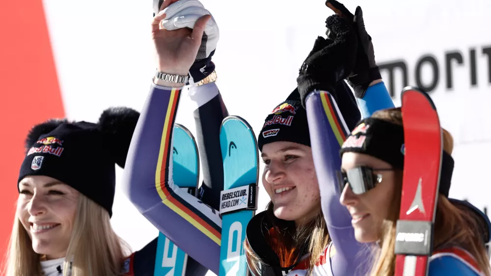 Germany's Emma Aicher, center, winner of an alpine ski, women's World Cup downhill, poses on the podium with second placed United States' Lindsey Vonn, left, and third placed Italy's Sofia Goggia in St. Moritz, Switzerland, Saturday Dec. 13, 2025. (AP Photo/Gabriele Facciotti)