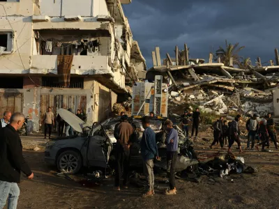 13 December 2025, Palestinian Territories, Gaza City: Palestinians inspect the site of an Israeli strike on a car in Gaza City. Photo: Omar Ashtawy/APA Images via ZUMA Press Wire/dpa