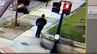 A monitor shows security camera footage of what police say is the Brown University shooting suspect walking along Hope Street after leaving the scene of shooting, in this screengrab taken from a handout video released December 13, 2025. Providence Public Information Officer/Handout via REUTERS  THIS IMAGE HAS BEEN SUPPLIED BY A THIRD PARTY. NO RESALES. NO ARCHIVES. MANDATORY CREDIT.  Verification Lines: Reuters was able to verify the location by road layout, road signs and the traffic lights match with file and satellite images. Reuters was not able to independently verify the Date. Providence Police Department stated that a shooting at Brown University caused 2 death and 9 injuries in Providence, Rhode Island on Saturday (December 13, 2025)