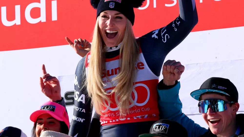 Alpine Skiing - FIS Alpine Ski World Cup - Women's Downhill - St. Moritz, Switzerland - December 13, 2025 Lindsey Vonn of the U.S. celebrates on the podium with her team after finishing second place in the Women's Downhill REUTERS/Denis Balibouse