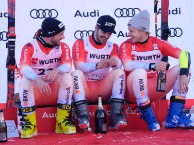 Switzerland's Loic Meillard, center, winner of an alpine ski, men's World Cup giant slalom event, sits by fellow-countrymen second placed Luca Aerni, left, and third placed Marco Odermatt, in Val d'Isere, France, Saturday Dec. 13, 2025. (AP Photo/Giovanni Auletta) (AP Photo/Giovanni Auletta)
