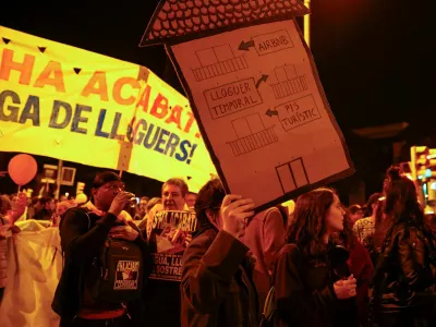 FILE PHOTO: A demonstrator holds a house-shaped sign that reads "from touristic flat to temporary rent to Airbnb" during a protest to demand lower housing rental prices and better living conditions, in Barcelona, Spain, November 23, 2024. REUTERS/Bruna Casas/File Photo