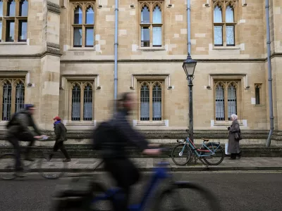 FILE PHOTO: People walk and cycle past a building at Oxford University in Oxford, Britain, December 5, 2025. REUTERS/Jaimi Joy/File Photo