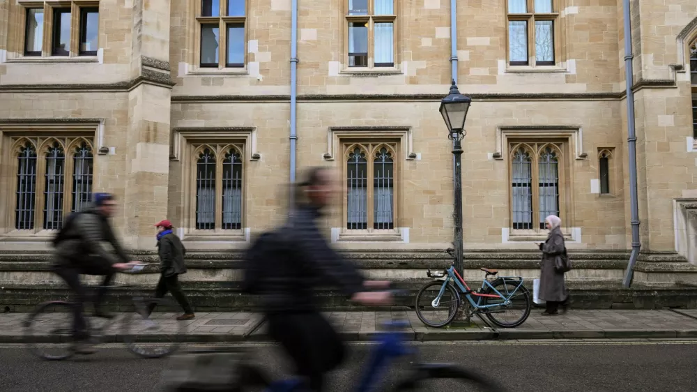 FILE PHOTO: People walk and cycle past a building at Oxford University in Oxford, Britain, December 5, 2025. REUTERS/Jaimi Joy/File Photo