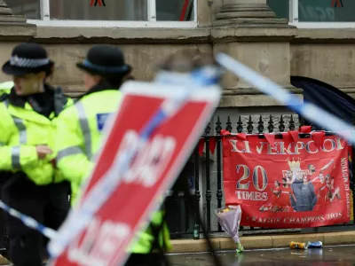 FILE PHOTO: Police officers operate as a Liverpool FC flag is seen in the background at the site of an incident where a car ploughed into a crowd of Liverpool fans during a parade celebrating their side's Premier League soccer title, in central Liverpool, Britain, May 27, 2025. REUTERS/Isabel Infantes/File Photo