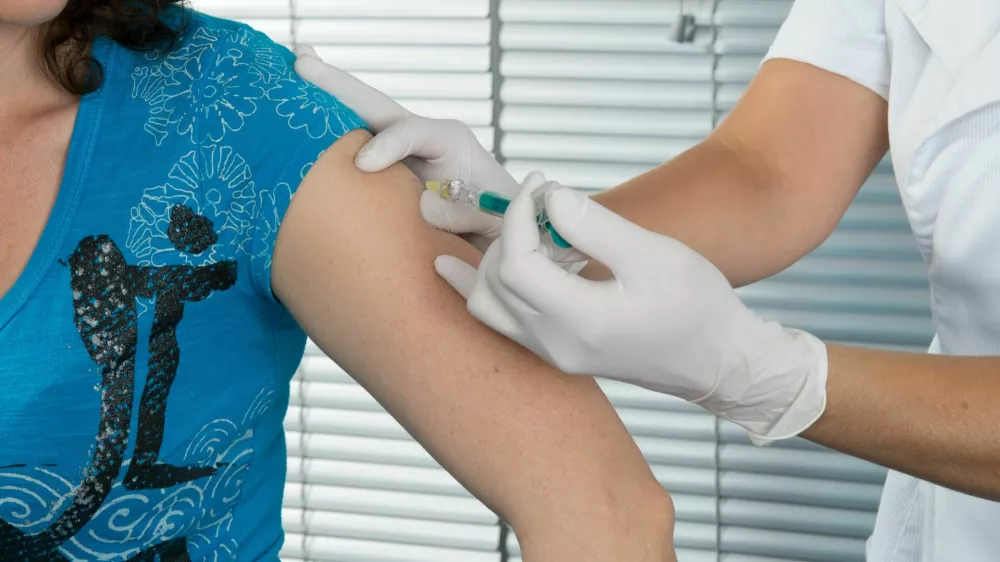 woman doctor vaccine injection with a syringe at hospital / Foto: Oceanprod