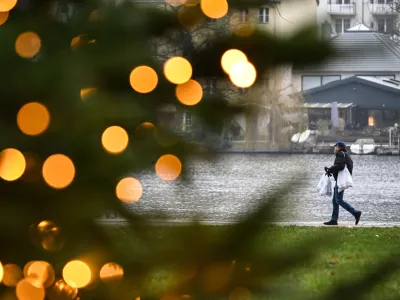 PRODUCTION - 22 December 2025, Berlin: A young man carrying shopping bags walks along the banks of the Mueggelspree in the old town of Koepenick. Photo: Britta Pedersen/dpa / Foto: Britta Pedersen