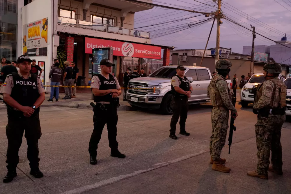 Police stand guard near the body of slain soccer player Mario Pineida at a butcher shop in Guayaquil, Ecuador, Wednesday, Dec. 17, 2025. (AP Photo/Cesar Munoz)