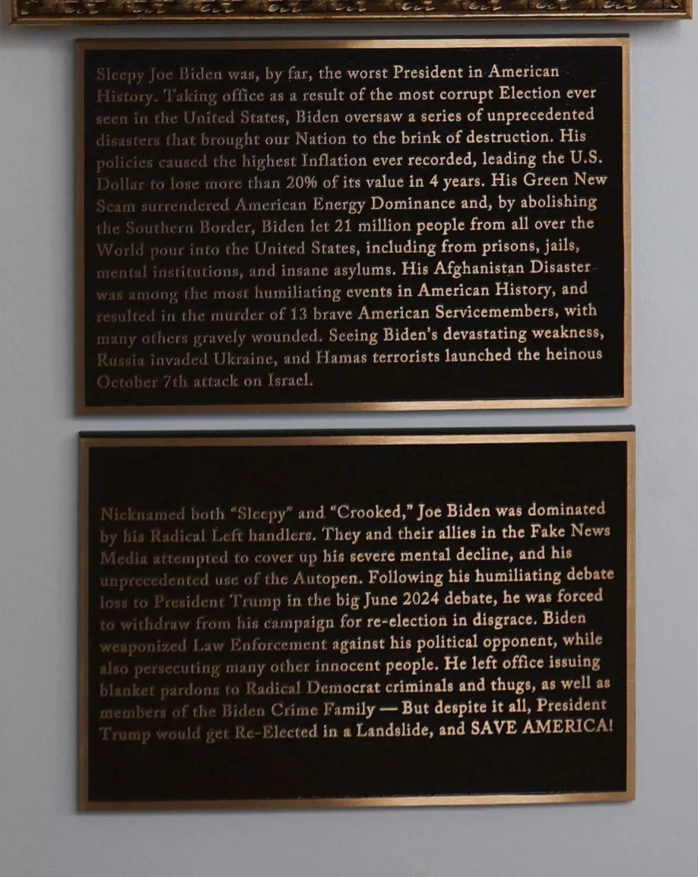 Plaques disparaging former U.S. President Joe Biden are seen under an image of an autopen signing Biden's signature on the "Presidential Walk of Fame," along the White House Colonnade in Washington, D.C., U.S., December 17, 2025. REUTERS/Jessica Koscielniak