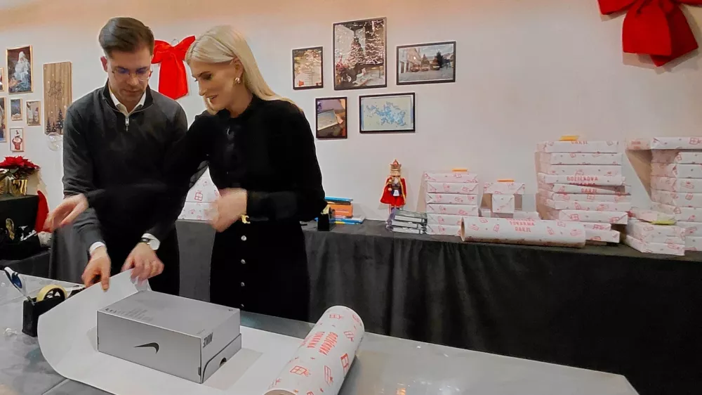 Milan Ninić s pomočjo prostovoljcev zavija darila za otroke v stiski. F Vesna Levičnik