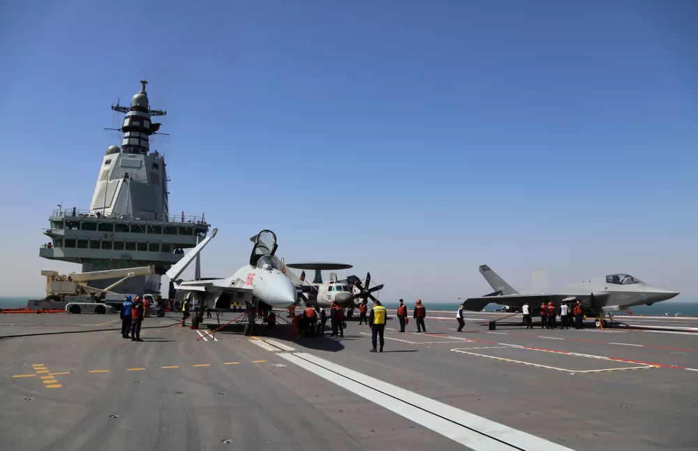 In this undated file photo released by Xinhua News Agency, crew members work on carrier-based aircraft from left, J-15T jet fighter, KJ-600 AWACS and J-35 stealth fighter jet on the flight deck of China's third conventionally powered aircraft carrier, the Fujian as they conduct the electromagnetic catapult-assisted takeoff and arrested landing trainings on the aircraft carrier during a maiden sea trial. (Li Tang/Xinhua via AP, file)