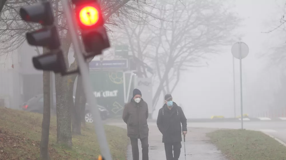 Men wear face masks on a foggy day in Sarajevo, Bosnia, Thursday, Dec. 18, 2025. (AP Photo/Armin Durgut)