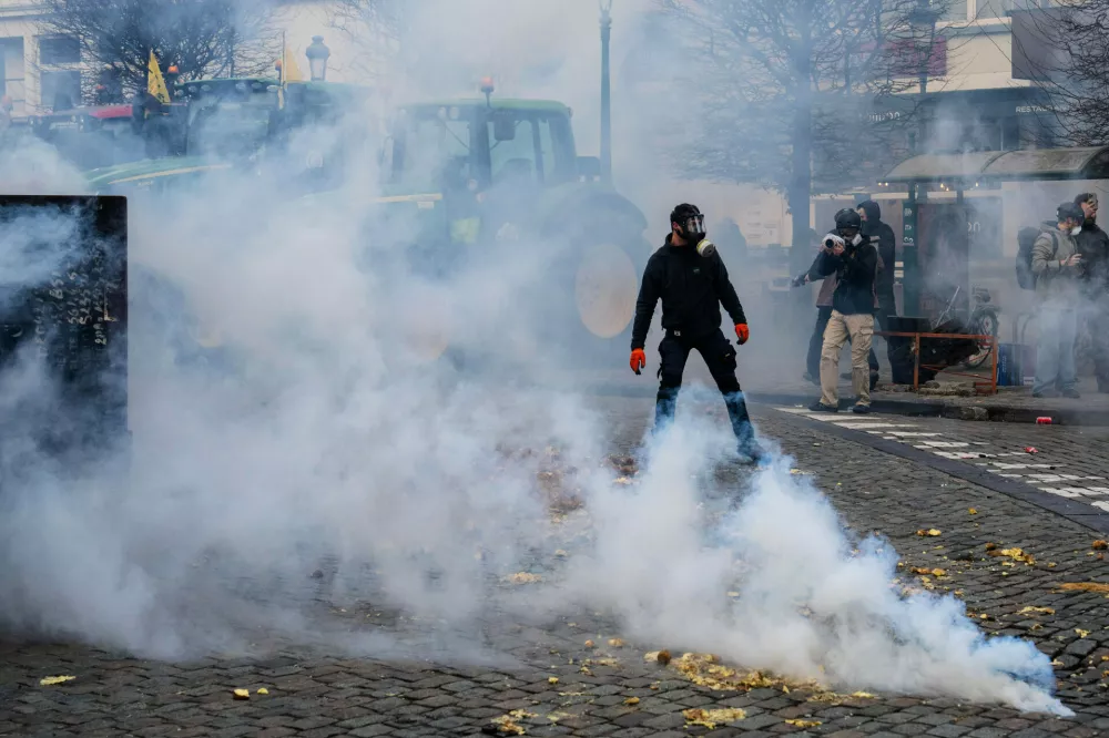 Police fire tear gas to try and disperse European farmers protesting outside a gathering of European leaders at the EU Summit in Brussels, Thursday, Dec. 18, 2025. (AP Photo/Marius Burgelman)