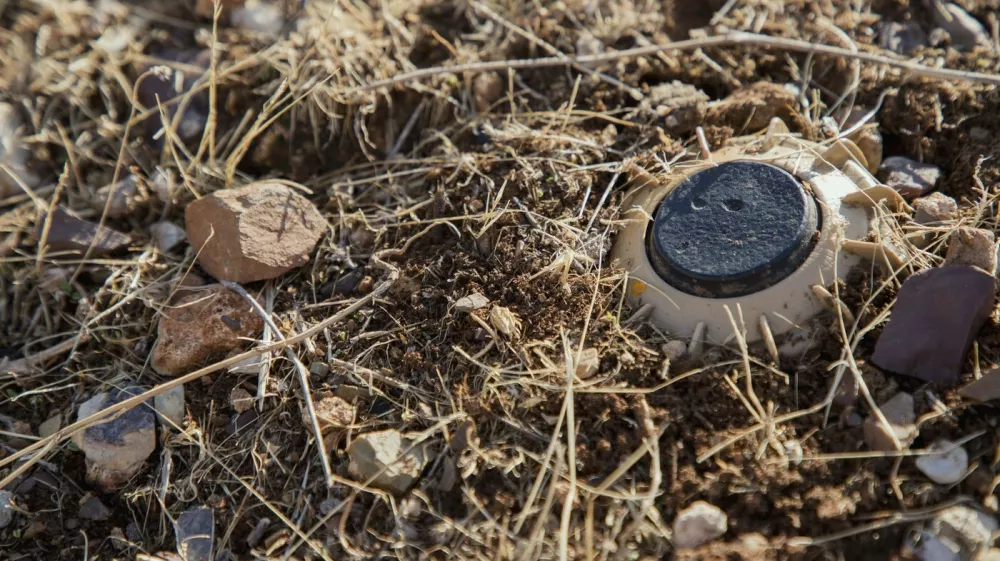 A landmine uncovered by Hoshyar Ali remains partially buried in rocky soil in Halabja, Iraq, on November 20, 2025. He has been clearing landmines for over four decades, a task he began after the Iran-Iraq war when thousands of mines were planted along the border. Despite losing both legs and several family members to explosions, he continues to volunteer in mine removal. Locals call him "man of the mines," and he is building a museum in his village to display defused explosives for future generations.//MIDDLEEASTIMAGES_MEI799/Credit:Showan Sulaiman/MEI/SIPA/2511231254,Image: 1054149849, License: Rights-managed, Restrictions:, Model Release: no