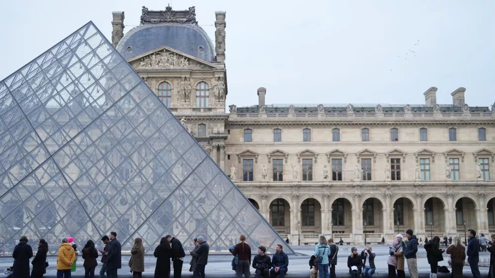 People wait for the Louvre museum to open as employees at the Louvre Museum vote to extend a strike that has disrupted operations at the world's most visited museum, Thursday, Dec. 18, 2025 in Paris. (AP Photo/Thibault Camus)