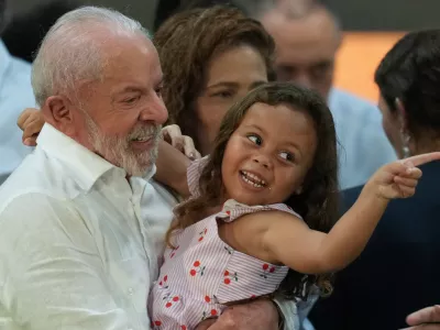 Brazilian President Luiz Inacio Lula da Silva hugs a child during a Christmas event with the families of collectors of recyclable trash in Sao Paulo, Friday, Dec. 19, 2025. (AP Photo/Andre Penner)