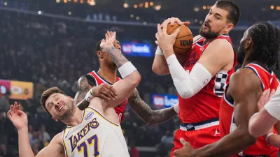 Los Angeles Clippers center Ivica Zubac, left, gets a rebound against Los Angeles Lakers forward/guard Luka Doncic during the first half of an NBA basketball game Saturday, Dec. 20, 2025, in Inglewood, Calif. (AP Photo/Jae C. Hong)