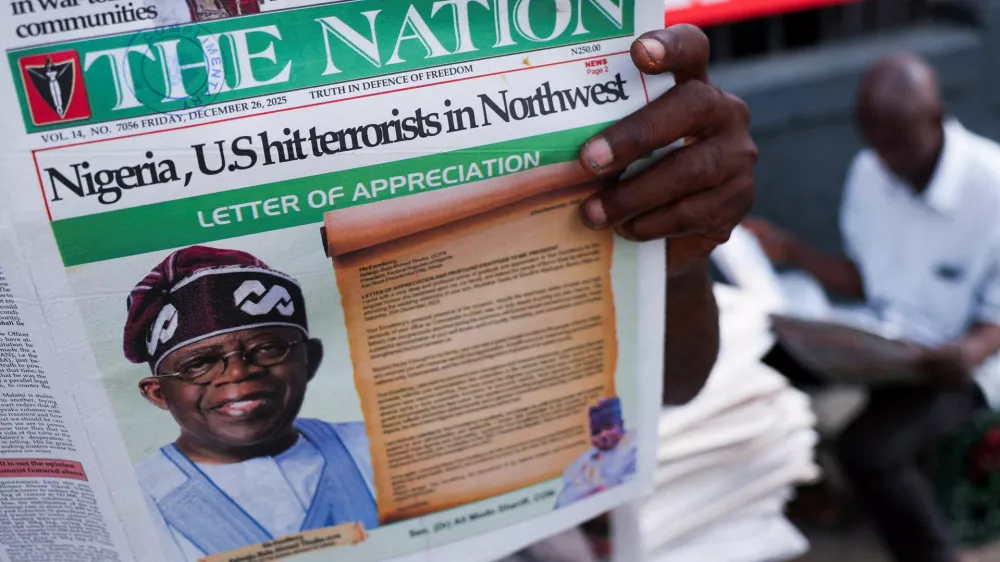 People read newspapers reporting on U.S. airstrikes against Islamic State militants in Nigeria, according to U.S. President Donald Trump and the U.S. military, in Lagos, Nigeria, December 26, 2025. REUTERS/Sodiq Adelakun