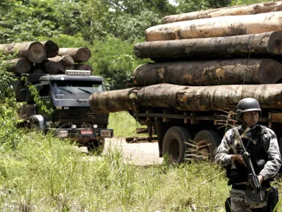 A soldier stands guard in front of a truck loaded with logs that were illegally cut from the Amazon rain forest in Tailandia,in the northern Brazilian state of Para, Monday, Feb. 25, 2008. About 200 heavily armed troops of Brazil's Top National Police Force arrived Monday in this remote town of the northern jungle state of Para to boost efforts to crack down on illegal logging, the government news service Agencia Brasil said. (AP Photo/Beto Barata-Agencia Estado)