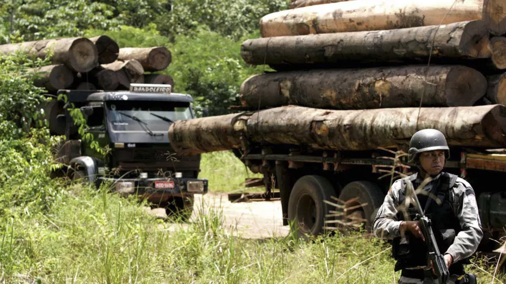 A soldier stands guard in front of a truck loaded with logs that were illegally cut from the Amazon rain forest in Tailandia,in the northern Brazilian state of Para, Monday, Feb. 25, 2008. About 200 heavily armed troops of Brazil's Top National Police Force arrived Monday in this remote town of the northern jungle state of Para to boost efforts to crack down on illegal logging, the government news service Agencia Brasil said. (AP Photo/Beto Barata-Agencia Estado)