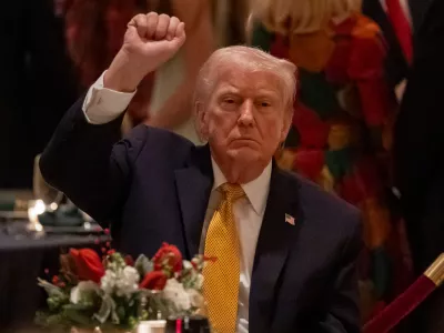 President Donald Trump pumps his fist at Christmas Eve dinner at his Mar-a-Lago club, Wednesday, Dec. 24, 2025, in Palm Beach, Fla. (AP Photo/Alex Brandon)
