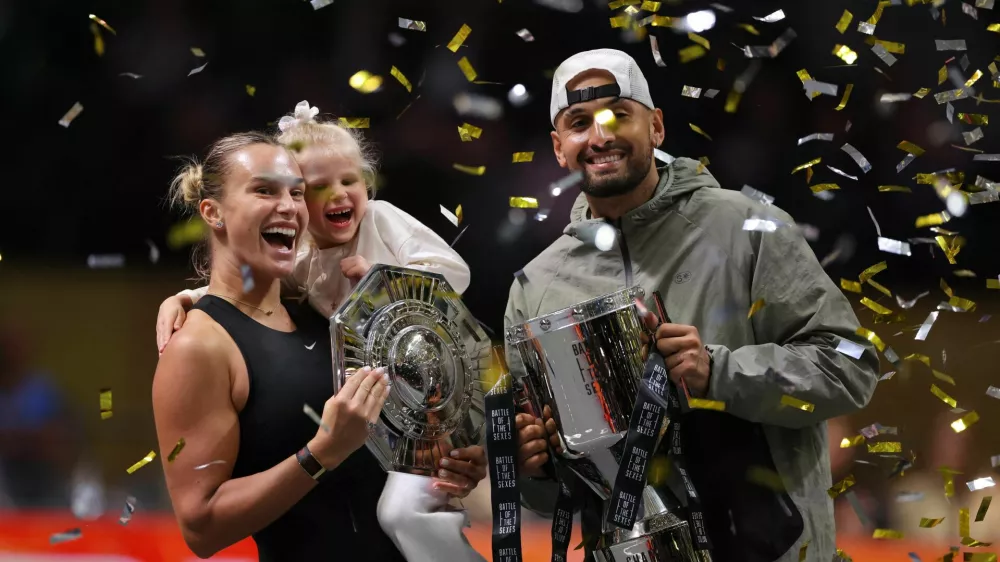 Tennis - 'Battle of the Sexes' - Nick Kyrgios v Aryna Sabalenka - Coca-Cola Arena, Dubai, United Arab Emirates - December 28, 2025 Belarus' Aryna Sabalenka, her goddaughter Nicole, and Australia's Nick Kyrgios celebrate with trophies after the match REUTERS/Amr Alfiky/Pool