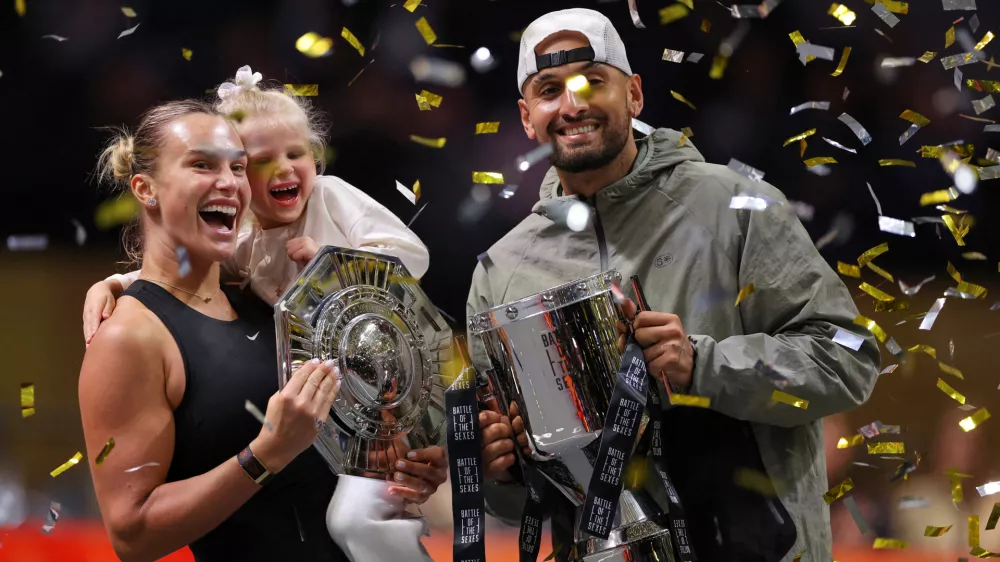 Aryna Sabalenka holds her goddaughter next to Nick Kyrgios as they pose with trophies after their Battle of the Sexes tennis match, in Dubai, United Arab Emirates, Sunday Dec. 28, 2025. (Amr Alfiky/Pool Photo via AP)