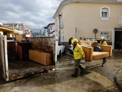 28 December 2025, Spain, Cartama: Infoca personnel move furniture as they help residents of the Los Cardiales neighborhood in Cartama following heavy rains in Malaga. The government has activated the Infoca Plan to carry out conditioning work in the Malaga municipality of Cartama, one of the most affected localities after heavy rains. Photo: &Aacute;lex Zea/EUROPA PRESS/dpa
