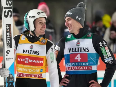 Domen Prevc, of Slovenia, after his second round jump, speaks with Timi Zajc, also of Slovenia, right, at the first stage of the Four Hills ski jumping tournament in Oberstdorf, Germany, Monday, Dec. 29, 2025. (AP Photo/Matthias Schrader)